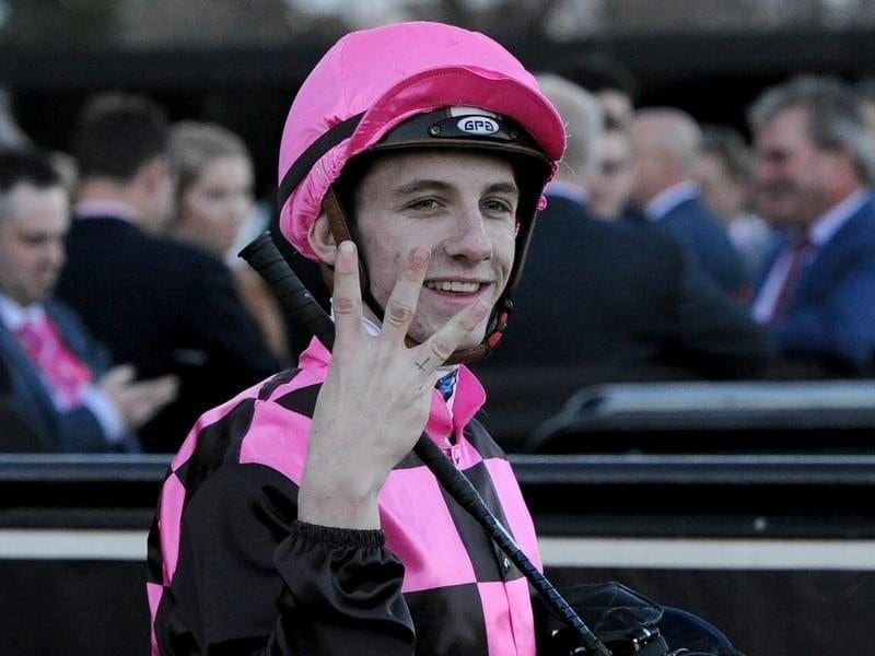 Jockey Beau Mertens holding up three fingers